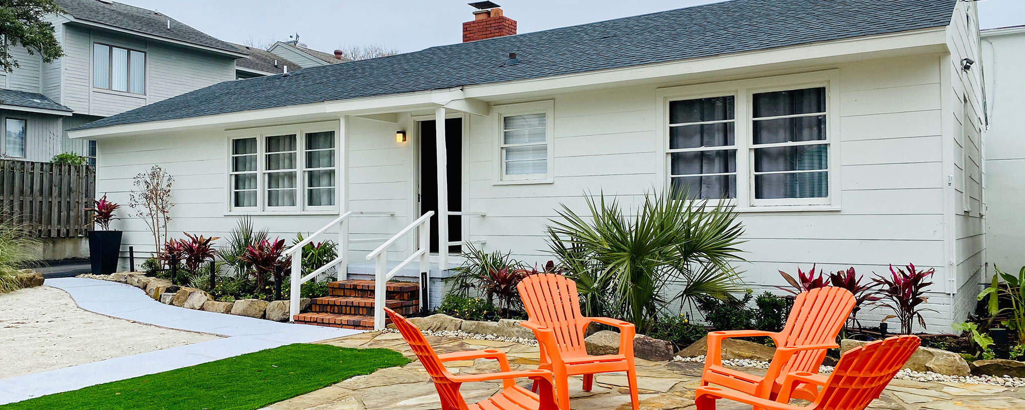 cottage exterior with 4 Adirondack chairs